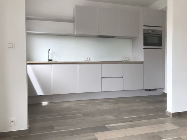 Witte keuken met lang werkblad en inbouwtoestellen
