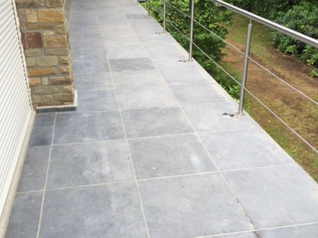 Pad in blauwe steen dat langs de tuin loopt