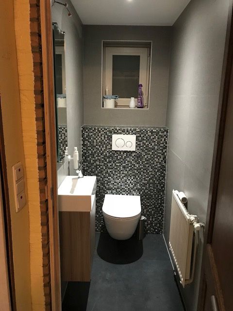 Toilet met hangend closet en een wand in zwart-wit mozaiektegels